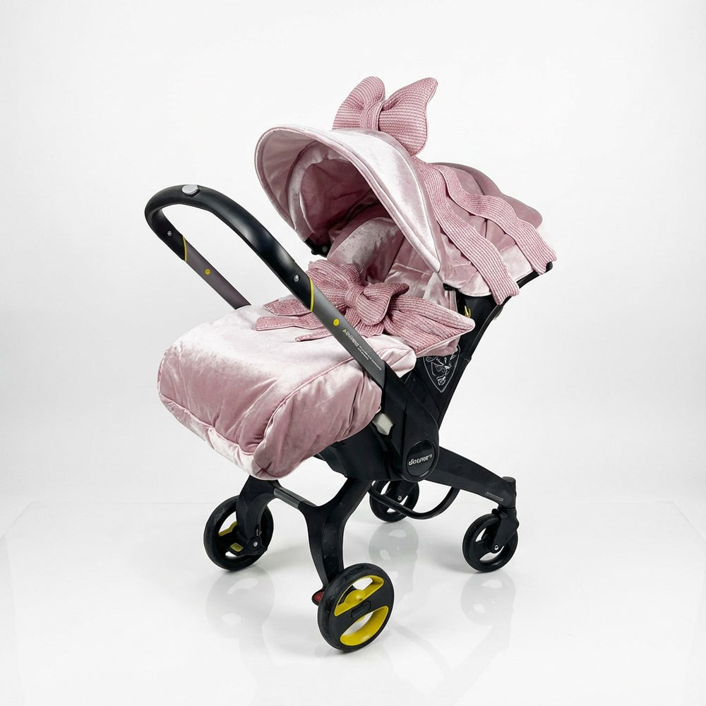 Pink baby stroller with decorative elements on a white background