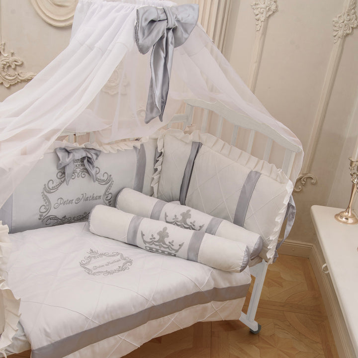 Baby crib with white and gray bedding in a decorated room