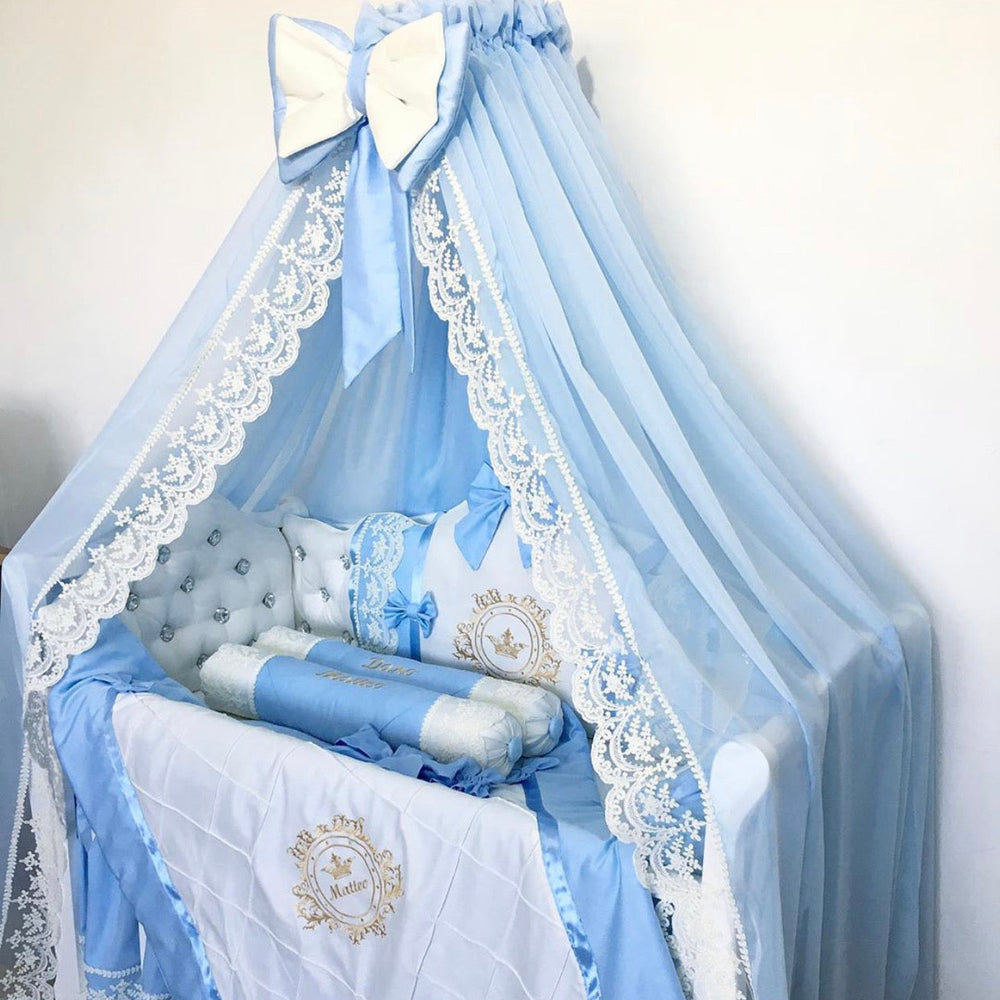 Baby crib with blue bedding and canopy on a white background