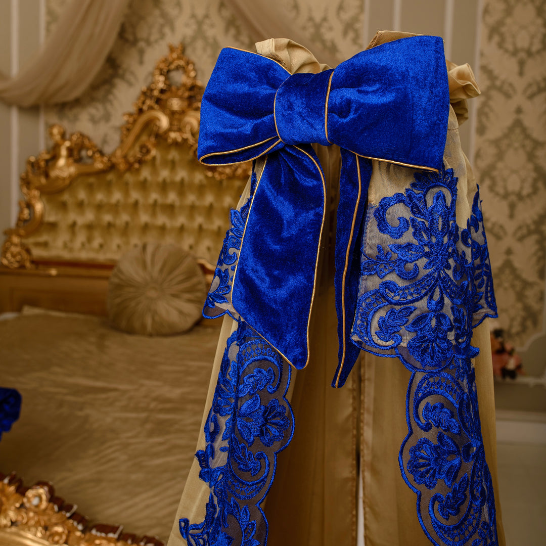 Decorative headboard with a large blue bow and intricate lace details in a bedroom setting.