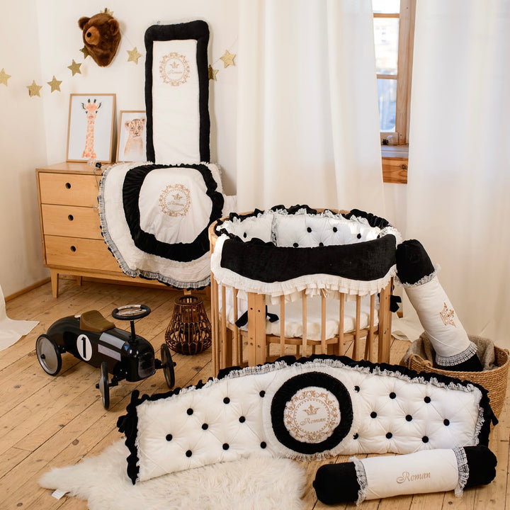 Nursery room with black and white baby crib set, wooden dresser, and toys.