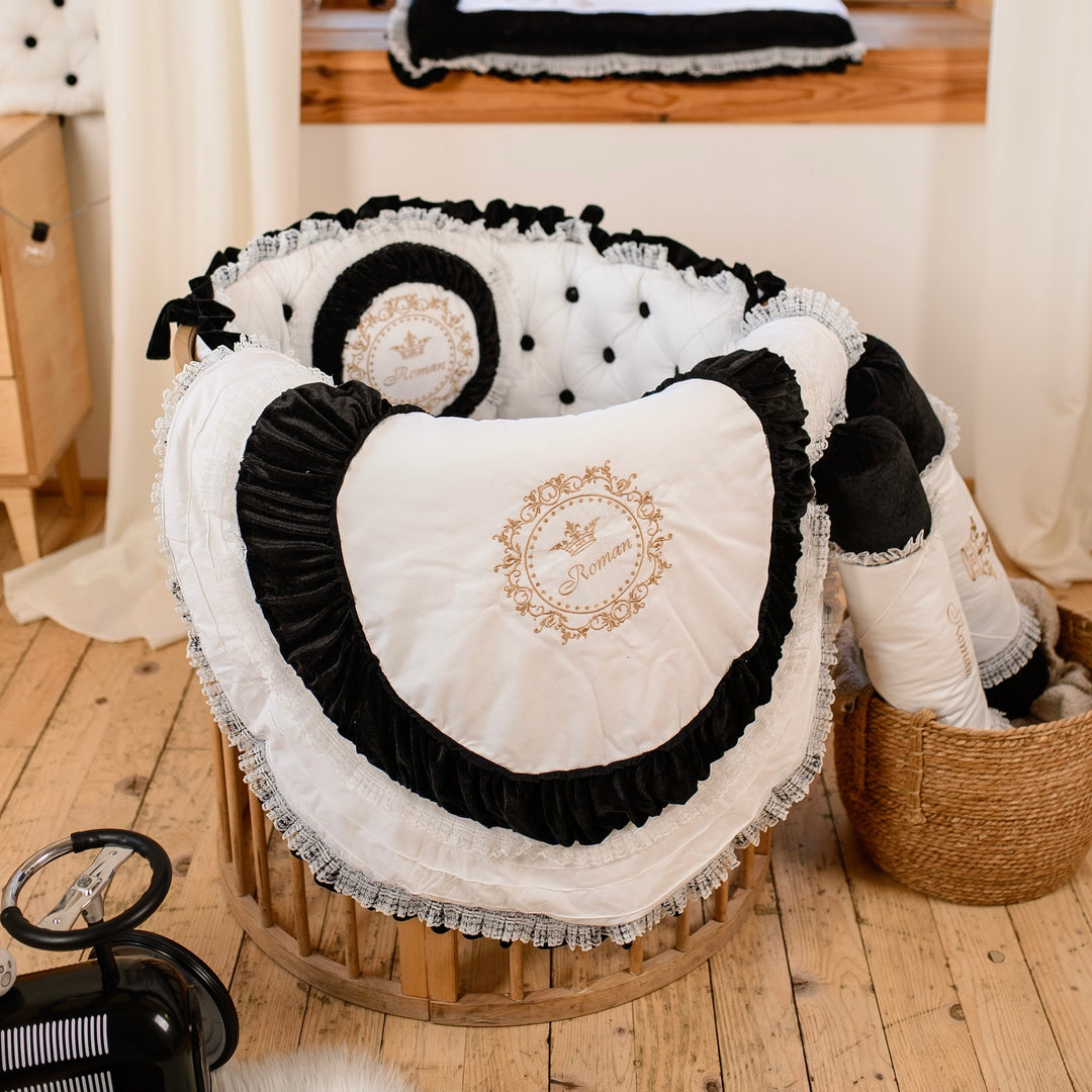 Decorative black and white cushion with embroidery on a wooden floor.