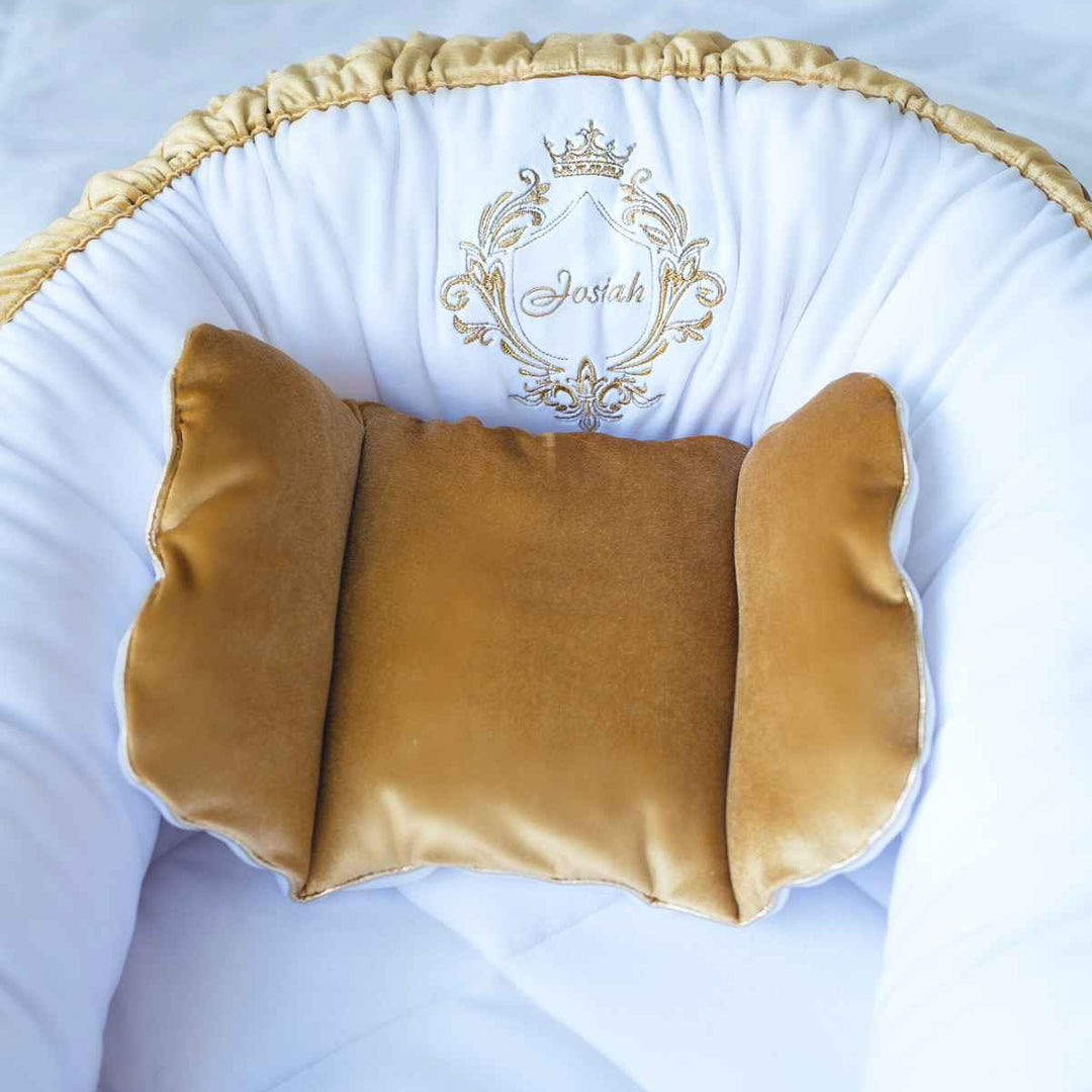 Gold cushion with a decorative logo on a white background