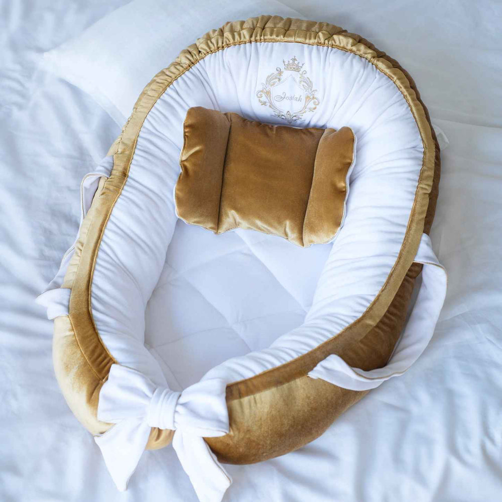 Baby nest with gold and white accents on a white background