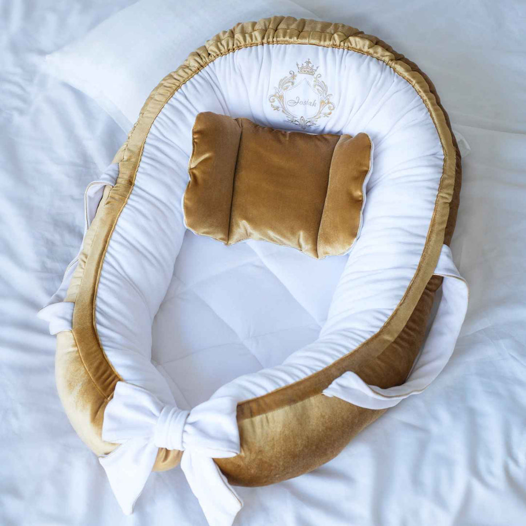 Baby nest with gold and white accents on a white background