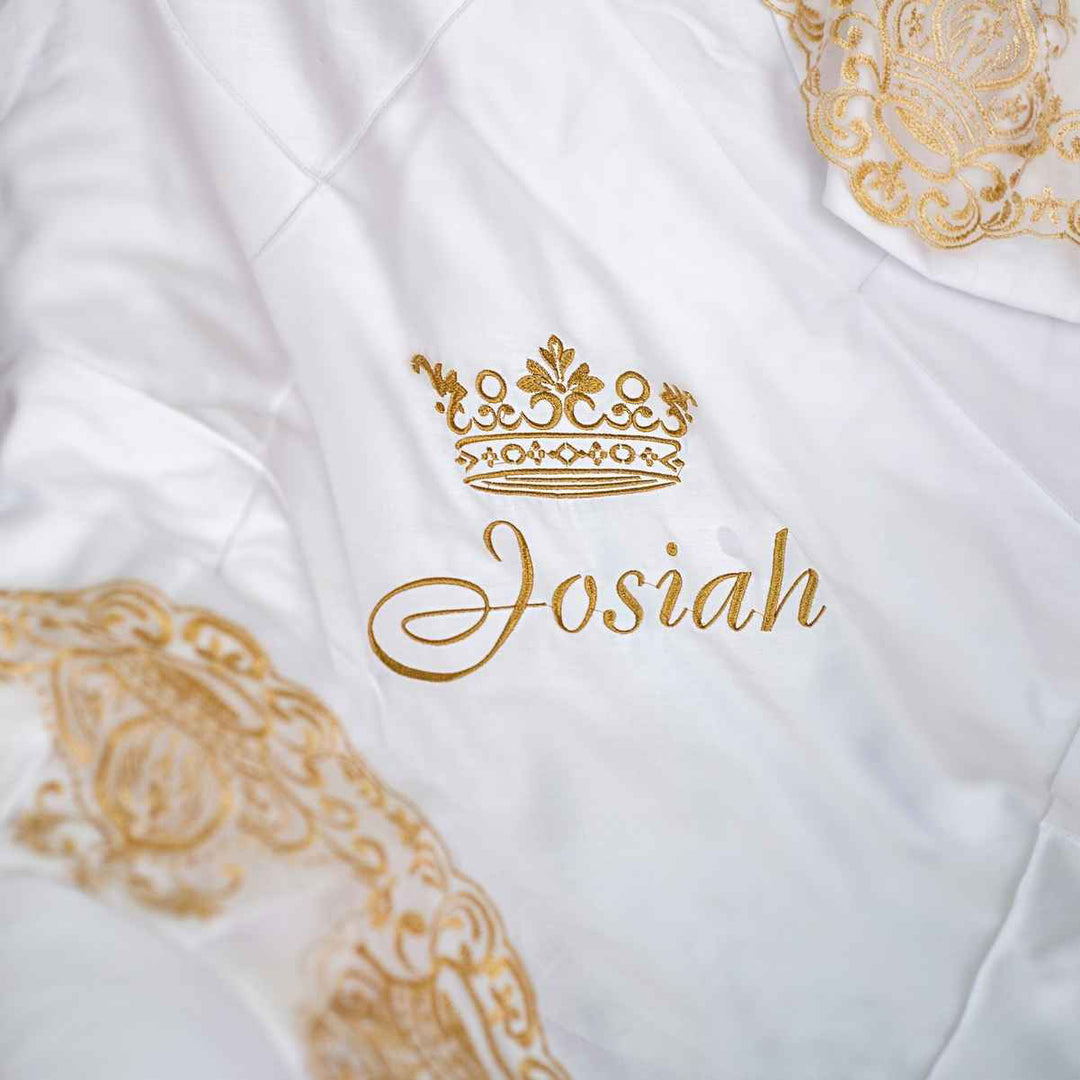 White garment with gold embroidery and 'Josiah' text on a white background