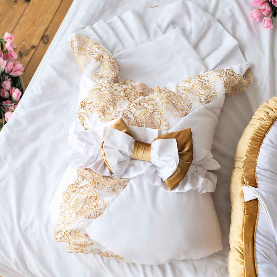 Decorative pillow with gold lace and a bow on a white surface.