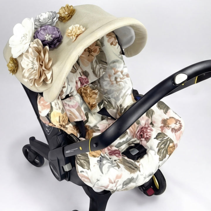 Beige floral Doona car seat cover with 3D flower canopy, side view.