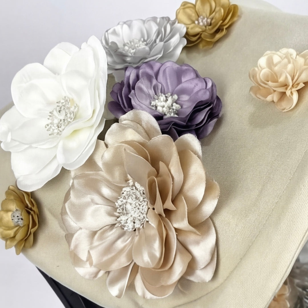 Close-up of beige Doona car seat canopy with handmade 3D fabric flowers in ivory, blush, lavender and gold.