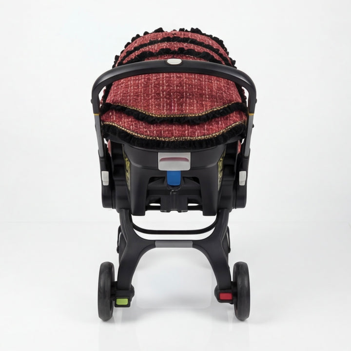 Doona+ red tweed car seat cover set, black ruffle trim, rear view on stroller base.