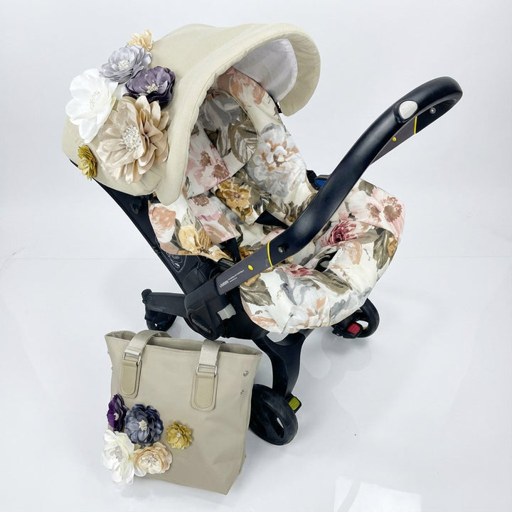 Floral-patterned baby car seat with matching bag on a white background