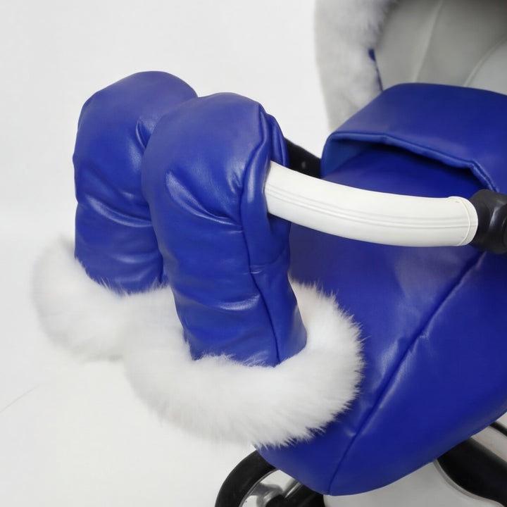 Close-up of blue stroller cover mittens with white arctic fox fur lining, attached to a stroller handle against a white background.