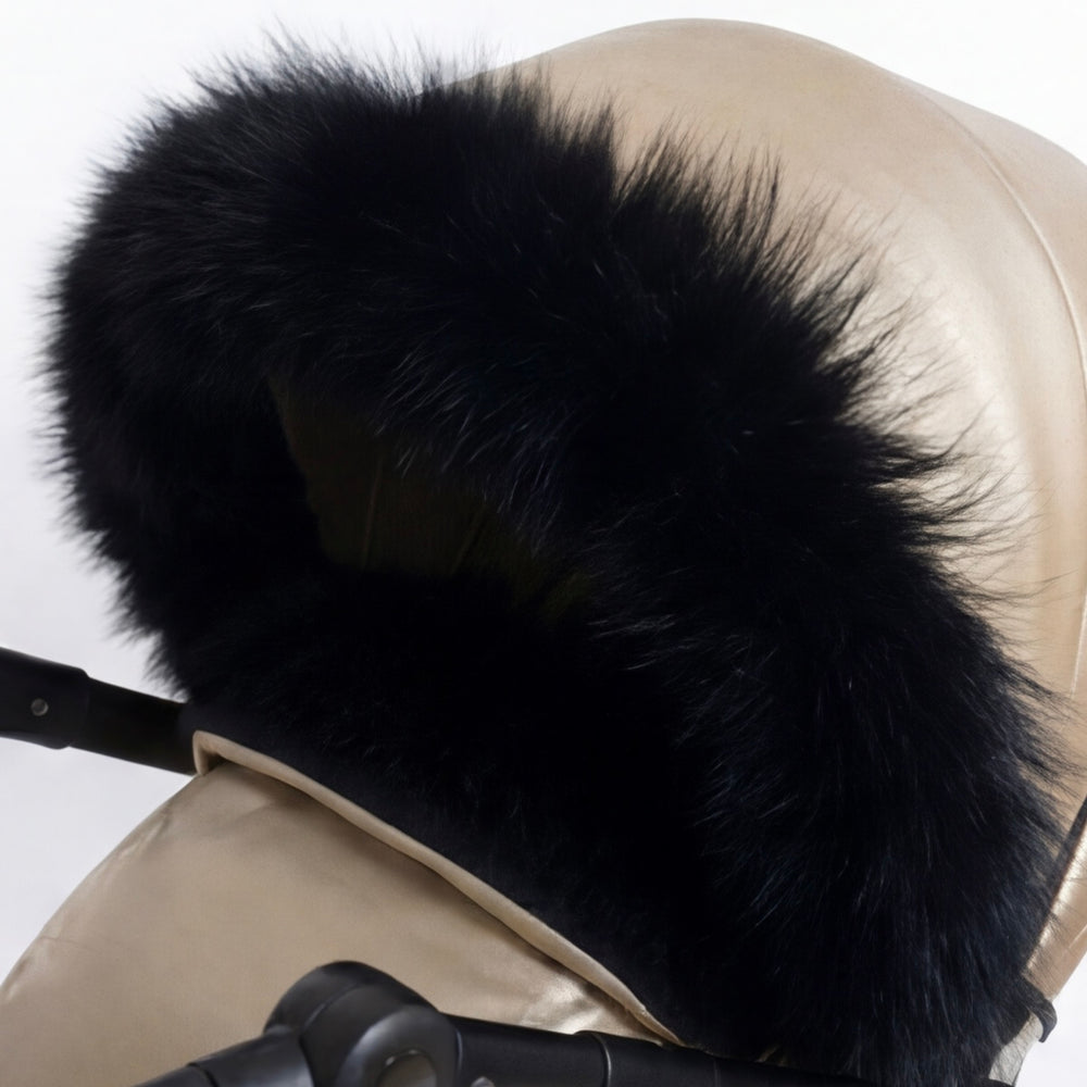 Close-up of a beige stroller cover canopy trimmed with black arctic fox fur, shown against a white background.