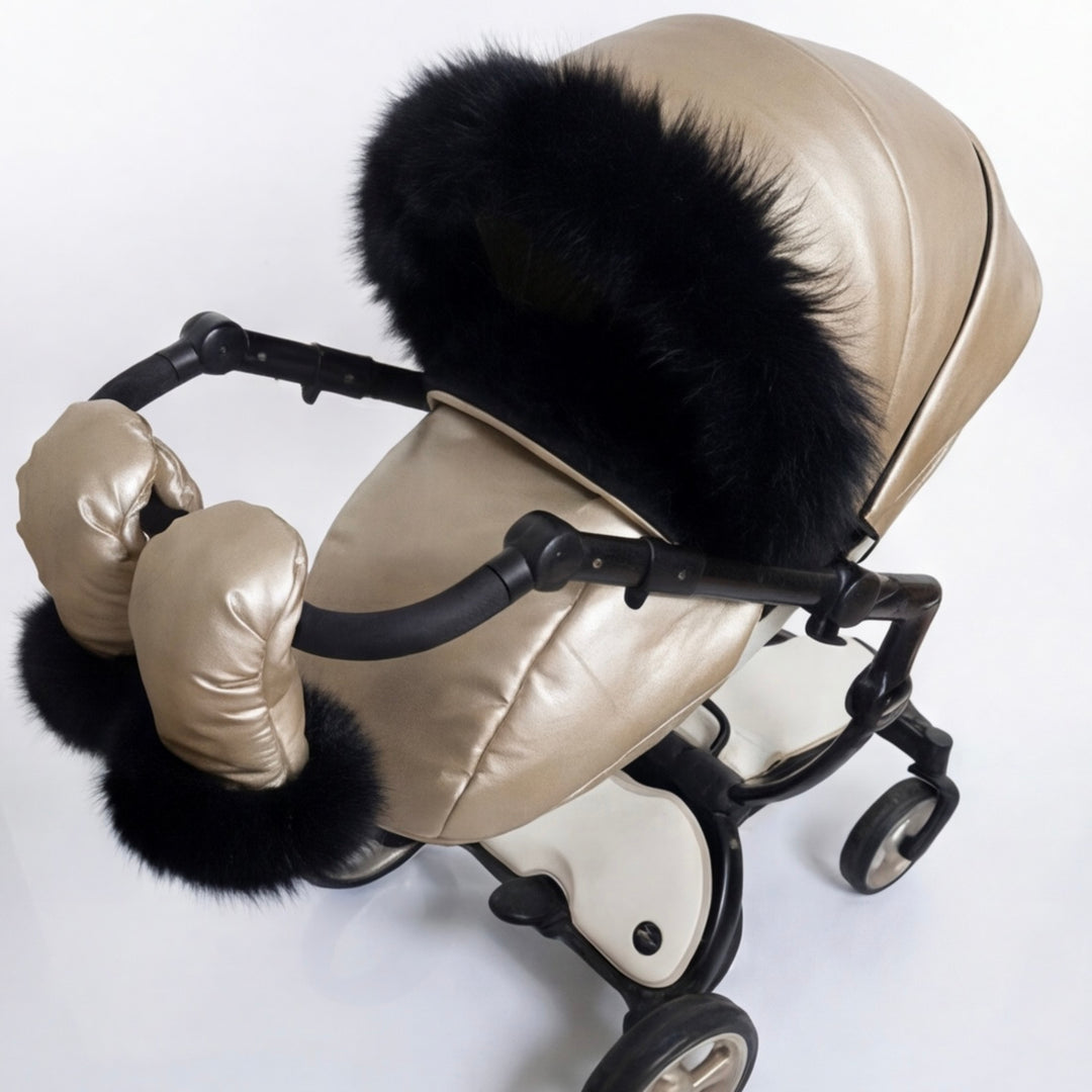 Side view of a beige stroller cover set with quilted canopy, black arctic fox fur trim, matching footmuff, and mittens, displayed on a stroller frame against a white background.
