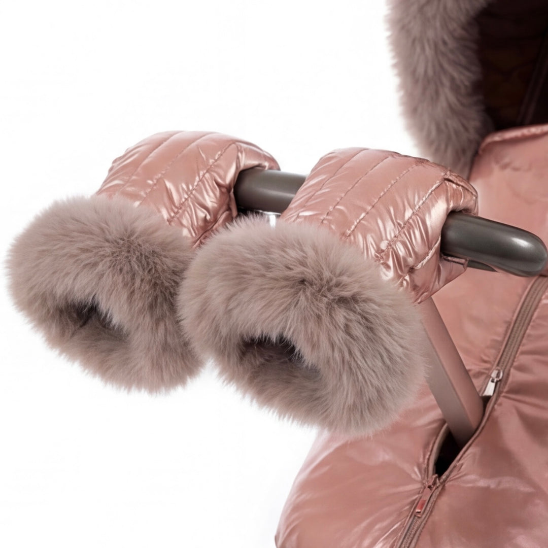 Close-up of rose gold metallic stroller cover mittens with arctic fox fur lining, attached to a stroller handle against a white background.