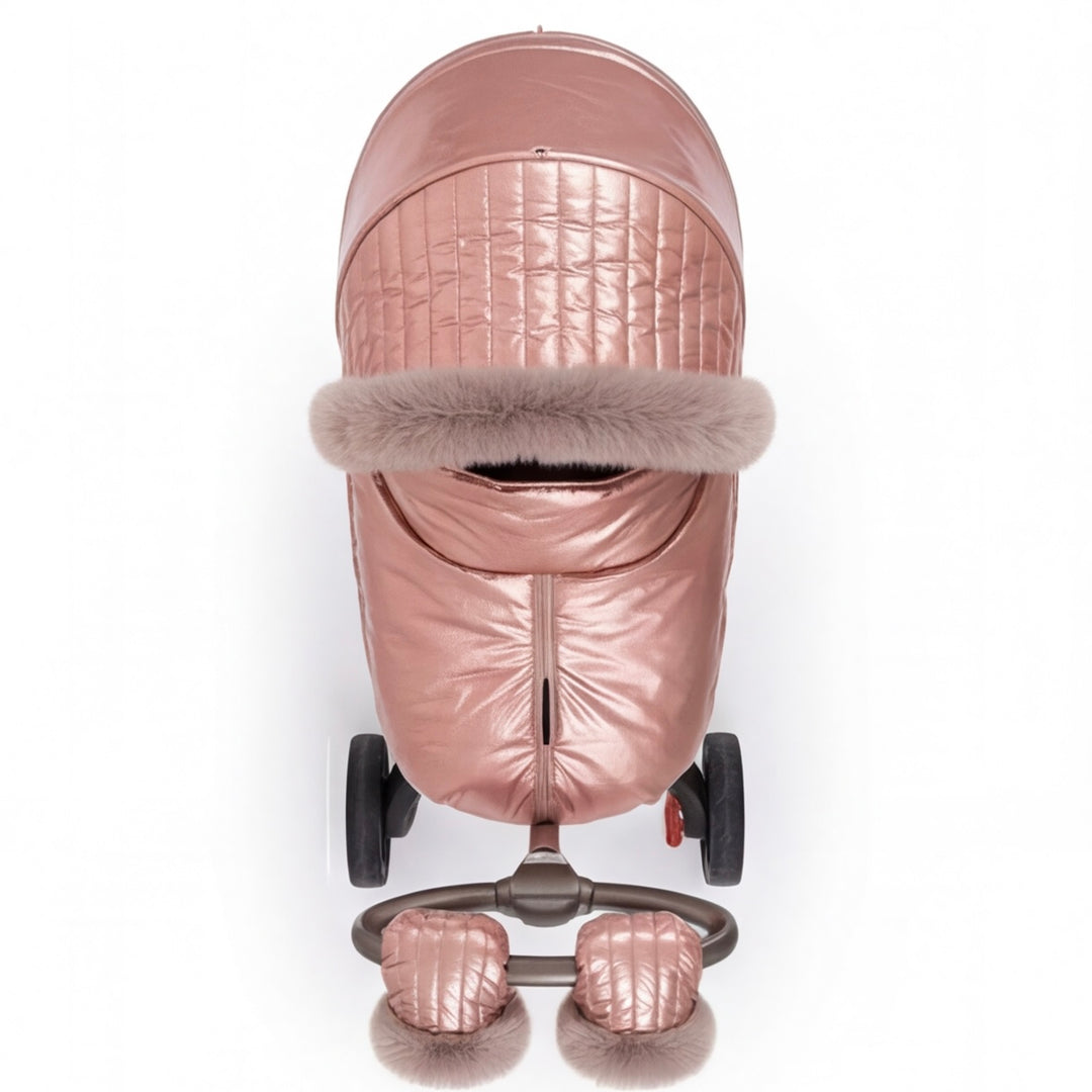 Front view of a rose gold metallic stroller cover with quilted canopy, beige faux fur trim, and matching footmuff, displayed on a stroller frame against a white background.