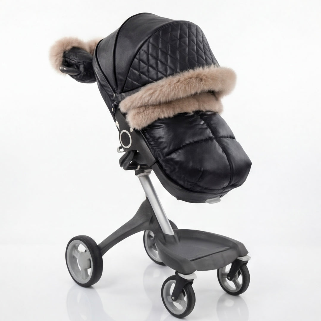 Black luxury stroller canopy cover with quilted leather-look fabric, beige faux fur trim, and matching footmuff, shown in side view on a modern stroller frame.