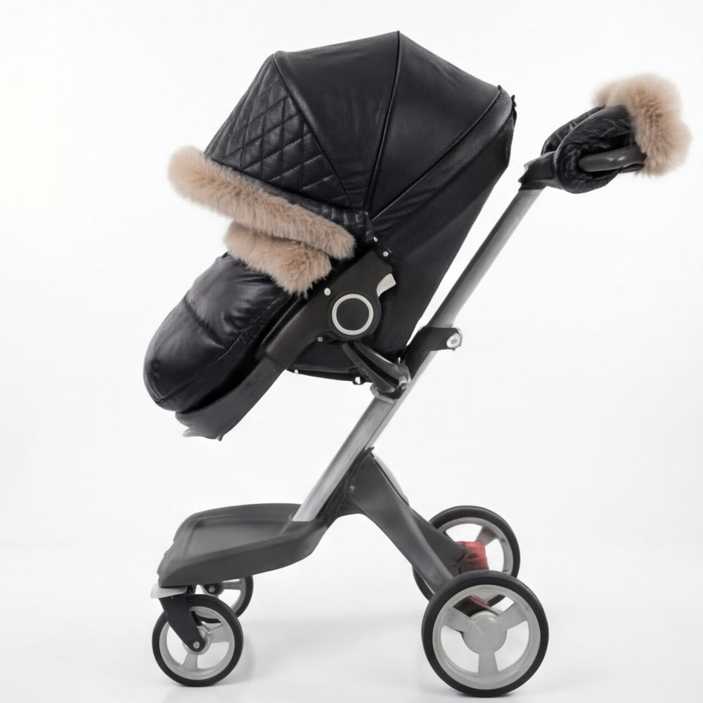 Black luxury stroller canopy cover with quilted leather-look fabric, beige fur trim, and matching footmuff, shown in side view on a modern stroller frame.
