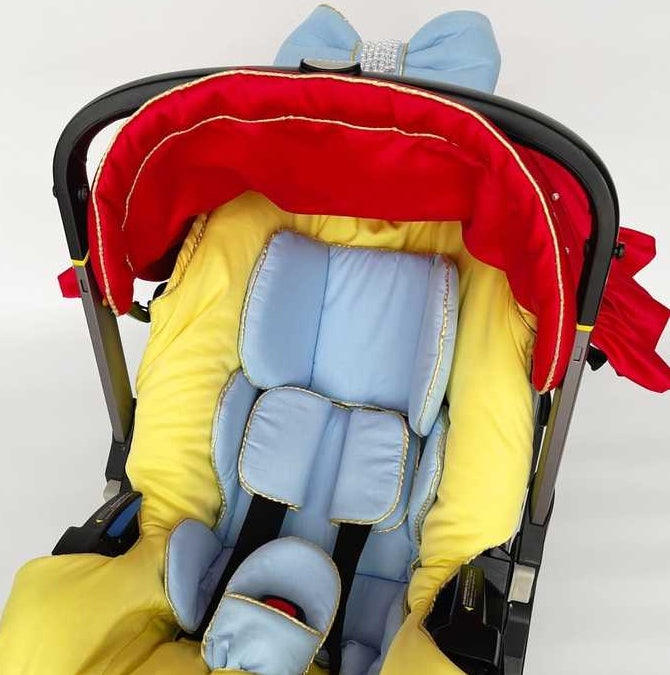 Snow White satin car seat canopy in red with gold embroidery, pearl details and light blue bow with rhinestone center, close-up on white background.