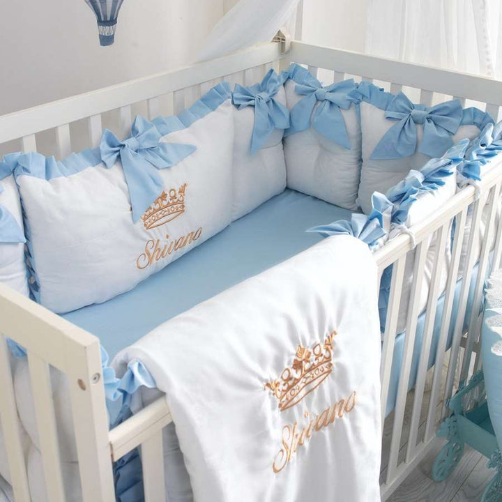 Baby crib with blue and white bedding featuring 'Shivana' branding.