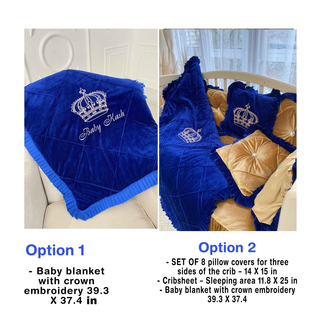 A baby crib bedding set with royal blue and gold colors, including embroidered crowns and ruffled bumpers, with a small crown placed on the baby's crib.