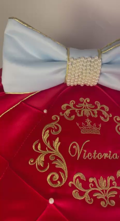 Snow White satin car seat canopy close-up, red quilted hood with gold “Victoria” embroidery and pearl studs, light blue bow with pearl center and gold trim, luxury baby car seat cover set detail.